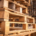 Wooden transport pallets in stacks.